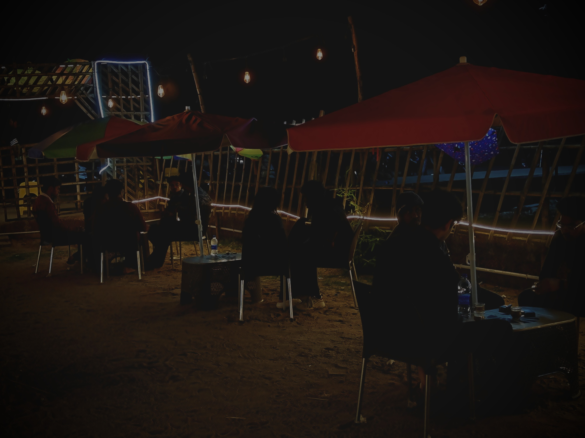 Cozy seating under green umbrella with fairy lights